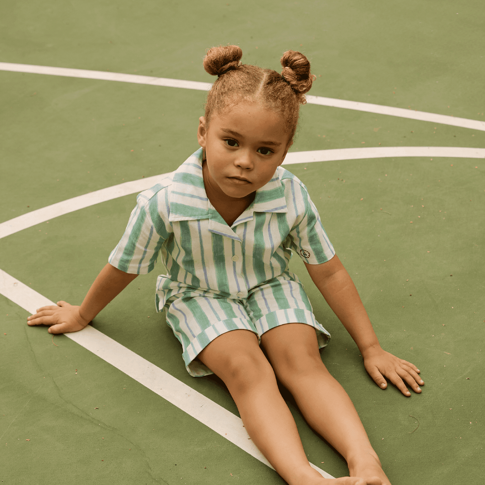 Dubai, UAE, Shopiva Lifestyle photo of Avaacha linen blend striped kids outfit featuring short sleeve shirt and shorts on an outdoor court